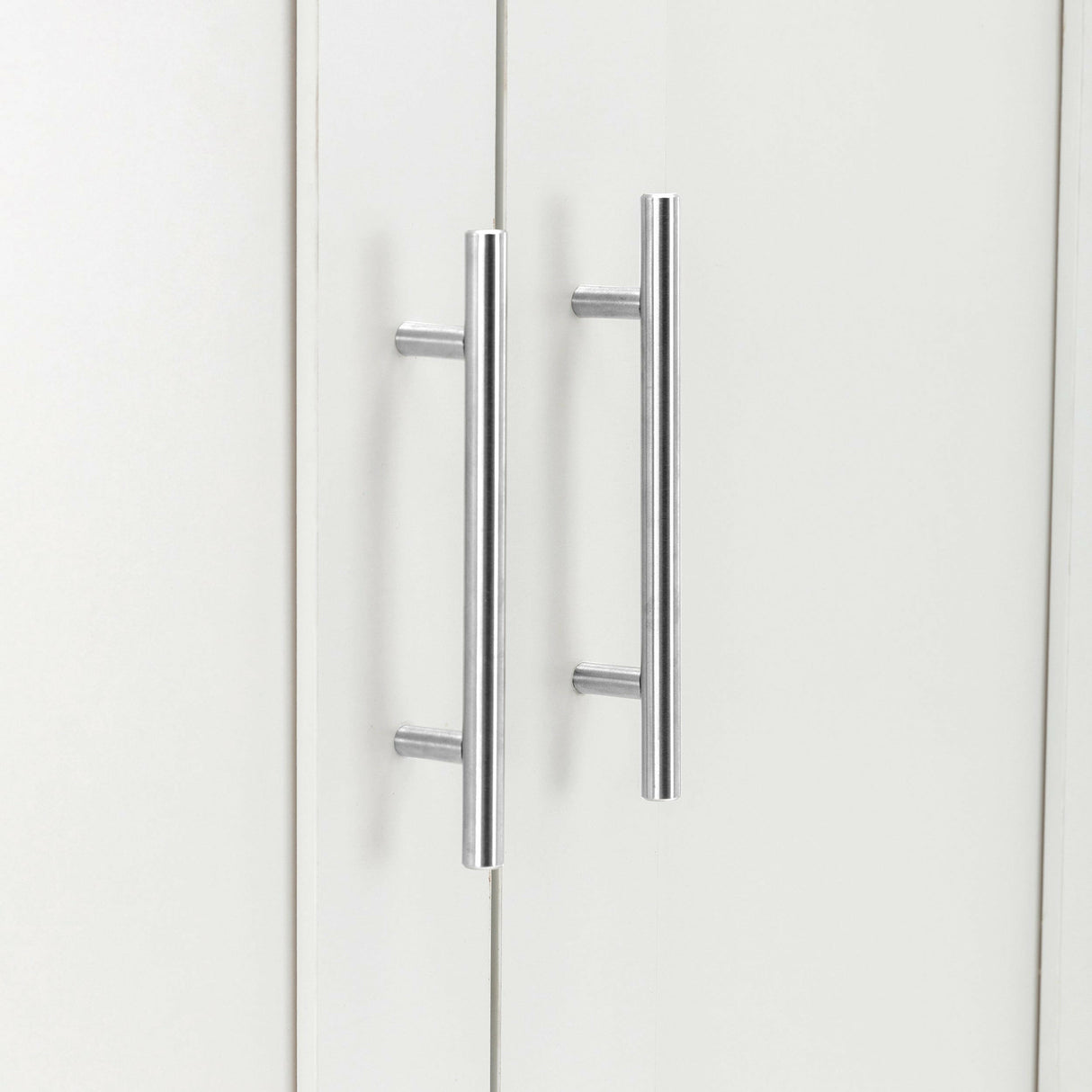 Close-up of white wardrobe doors with modern silver handles.