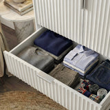 White wardrobe drawer interior with a folded stack of clothing storage and a smooth slide mechanism