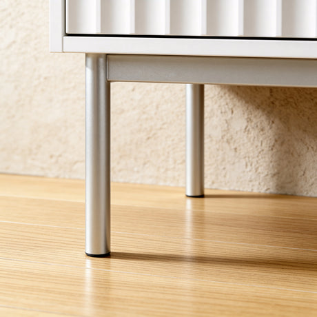 [White]  wardrobe base with silver metal legs supporting three door cabinet structure placed on the wooden floor