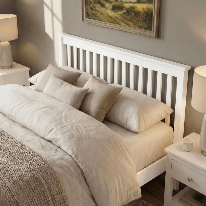 [White | Double] wooden double bed frame slatted headboard view, cream lamps flanking stacked beige pillows