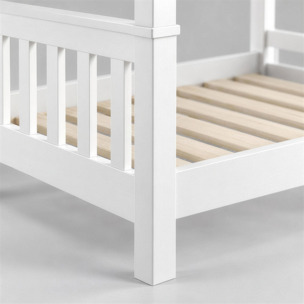 [White] Close-up of bunk bed corner showing slatted end panel, side rail, wooden slats and square leg