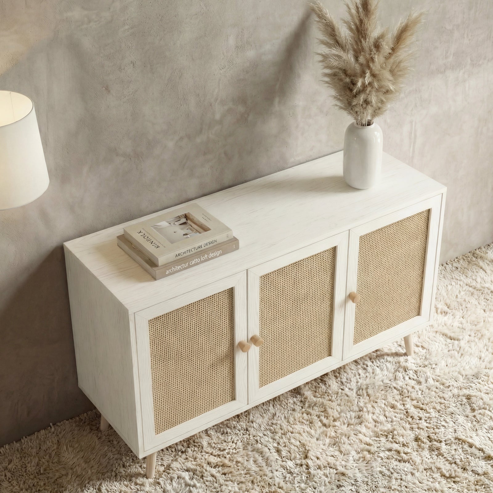 [White] Wovena rattan 3 door sideboard from raised angle showing flat top, vase glow from lamp at the upper left