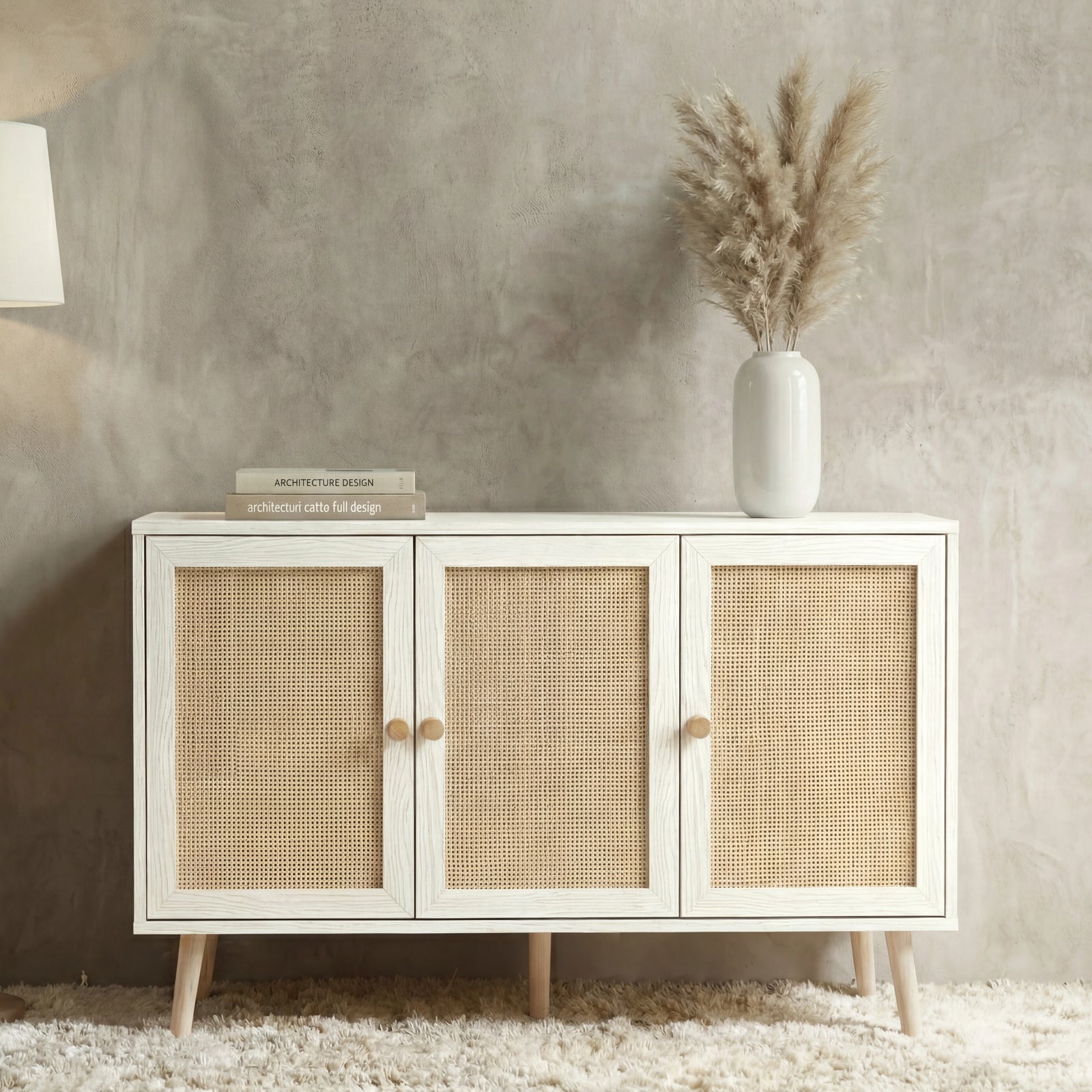 [White] Wovena Rattan 3 Door Sideboard - Adjustable Shelf White straight-on view styled with pampas grass against a concrete wall.