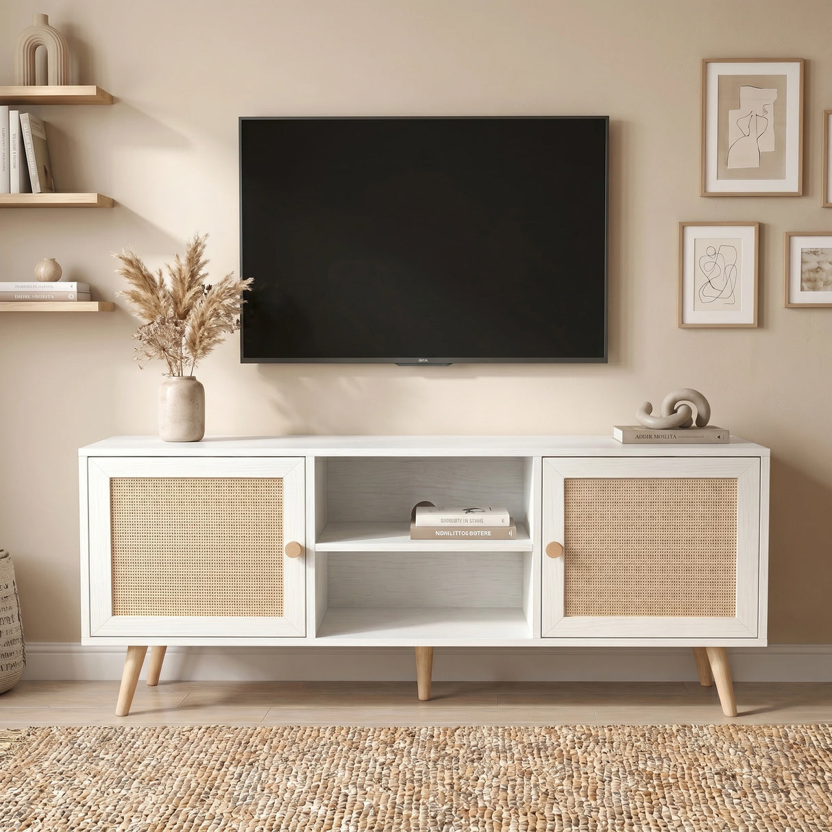 [White] Wovena Rattan TV Unit shown straight-on with pampas grass vase, books, sculptural decor, and gallery wall art above a mounted TV