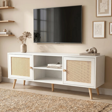 [White] Wovena Rattan TV Unit styled in a sunlit room with vase of dried flowers, books, abstract sculpture, and wall-mounted TV on a jute rug