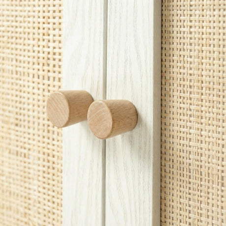[White] Wovena close-up of two solid cylindrical oak knob handles on the whitewashed centre door divider, with open-weave rattan panels filling the frame on both sides