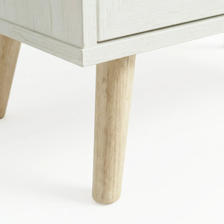 [White] Wovena sideboard close-up of two splayed pine legs at the front corner of the white painted base
