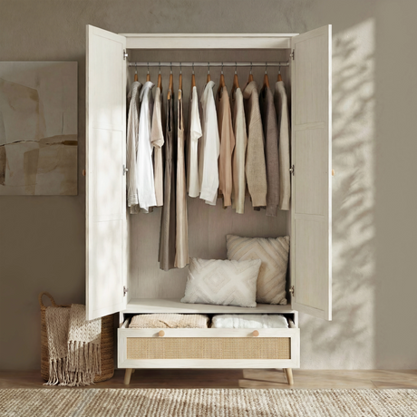 [White] Wardrobe 2 doors open showing hanging rail with neutral clothes and cushion on base in styled room