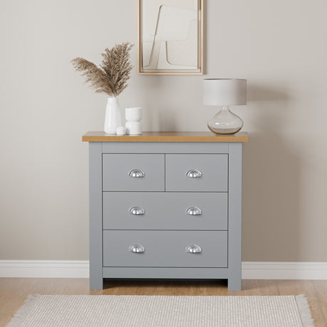 Wide and low chest of drawers with handles, top surface for lamp and flower pot.
