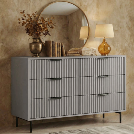 Grey flutrina 6 drawer chest with black metal legs styled against a neutral bedroom backdrop