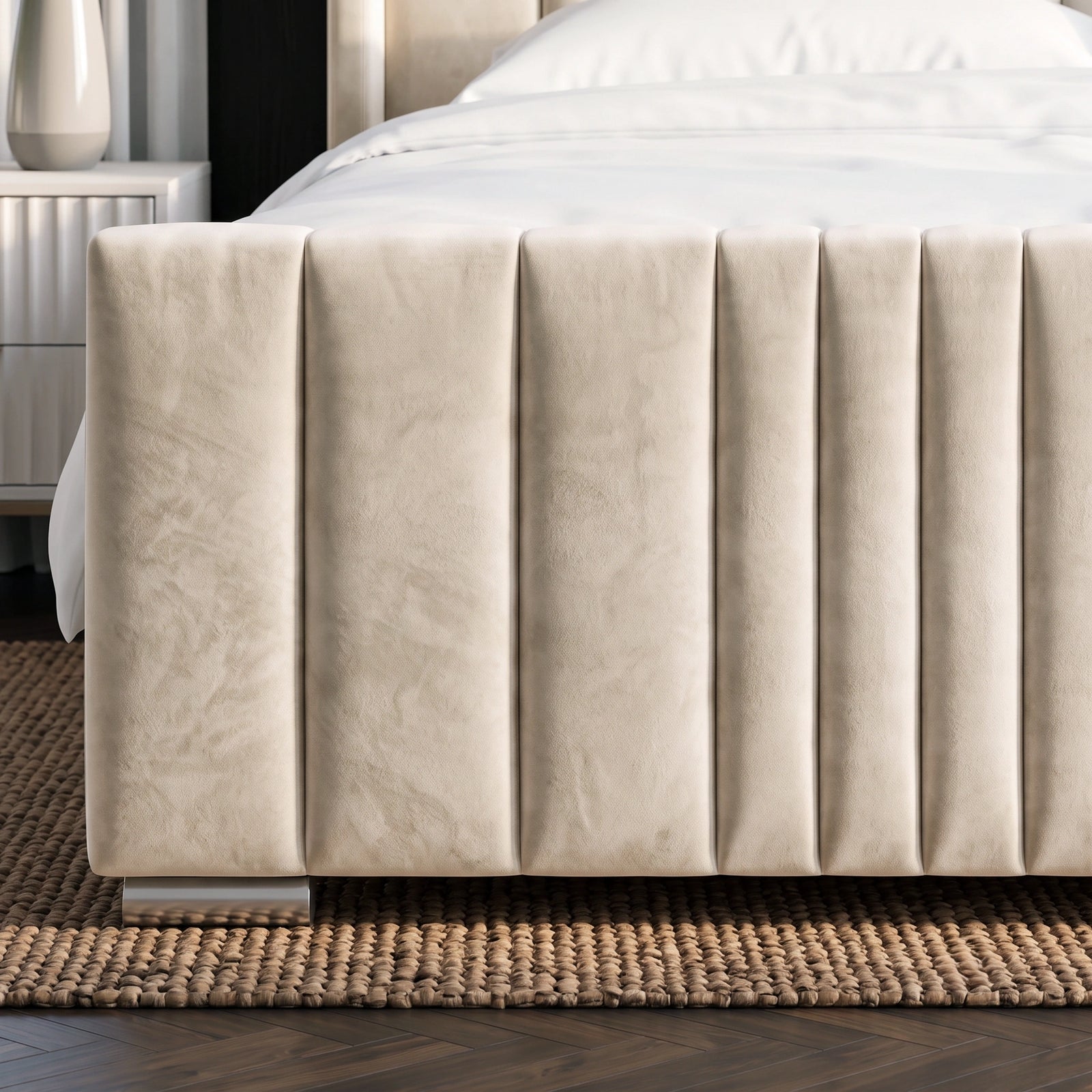 [Double | Beige] Close-up of matching vertical channel-stitched footboard with brass feet on textured rug