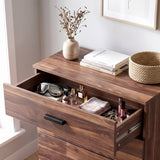 [Dark Bronx] nightstand with an open drawer showing cosmetics and accessories, styled in a bright room with a vase, books, and a woven basket on top.