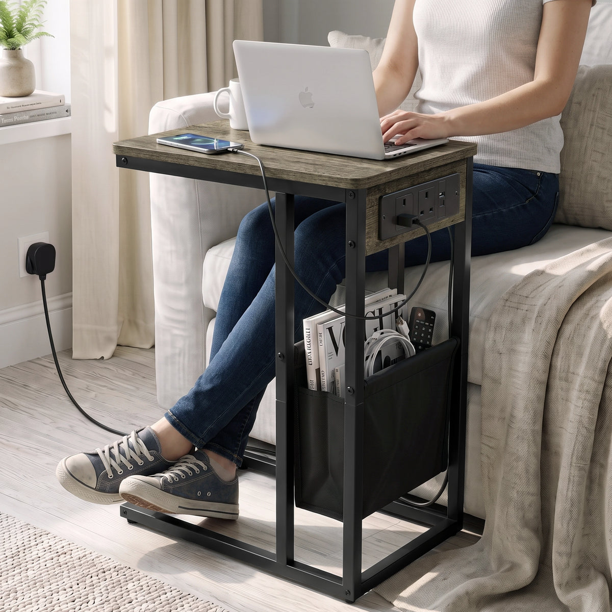 [Wooden Grey]C-shaped side table used for laptop work by sofa with charging station plugged in wall socket and storage pouch
