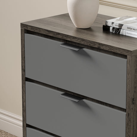 Wooden Grey Chest of drawers in two-tone finish, shown against a beige wall with decor on top in a bright room