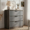 [Wooden Grey+Grey] Skova 3-drawer chest at an angle in a styled bedroom with lamp, botanical print, and eucalyptus on top