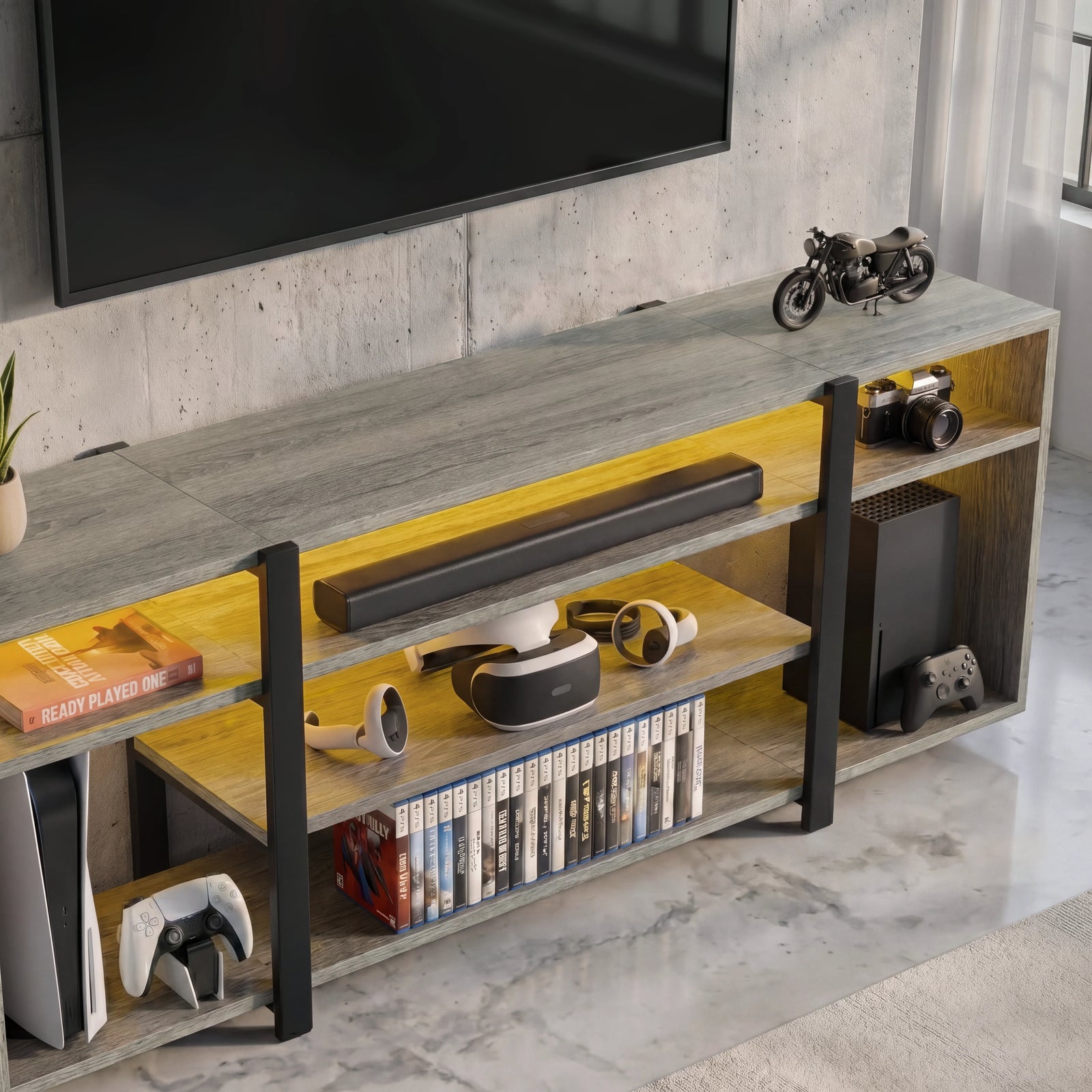 [Wooden Grey] Zelumi TV stand overhead close-up showing grey wood top surface, warm LED-lit shelves with VR headset, soundbar, console and game cases