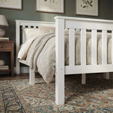 [Single | White] Wooden footboard close-up showing painted slats and sturdy square legs on patterned rug