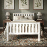 [Single | White + Pine] wooden bed frame with a slatted headboard and footboard, styled with beige bedding in a bedroom setting with two nightstands, lamps, framed botanical prints, and a patterned rug.