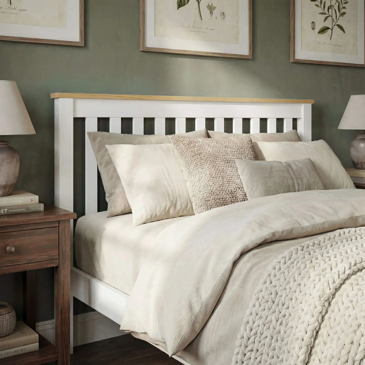 [Single | White + Pine] Neatly made bed with beige bedding and pillows in a room with framed artwork on the wall.