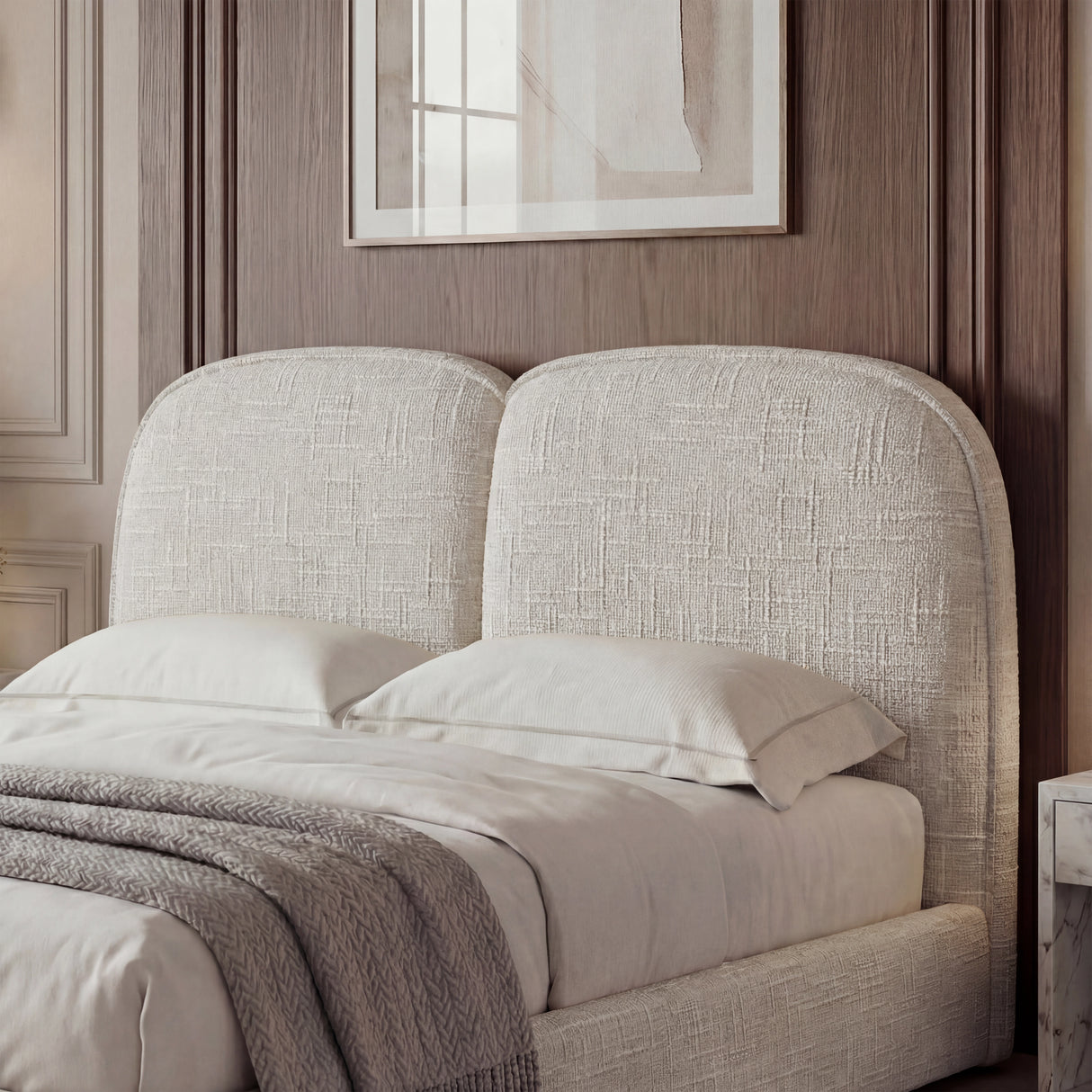 Double bed frame with a soft beige upholstered headboard, complemented by white bedding and a minimalist design
