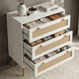 [White] Wovena chest of drawers with all three rattan-front drawers open showing folded clothing and accessories