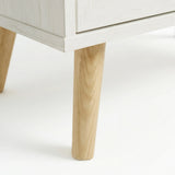 [White] Wovena chest detail showing tapered solid wood leg with white painted finish and natural wood grain contrast