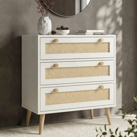 [White] Wovena chest of 3 drawers in a styled room with dark textured wall, round mirror, vase and books on top