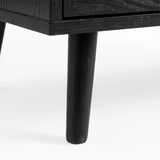 [Black] Wovena close-up of a solid tapered black leg of chest showing the wood grain texture and painted finish detail