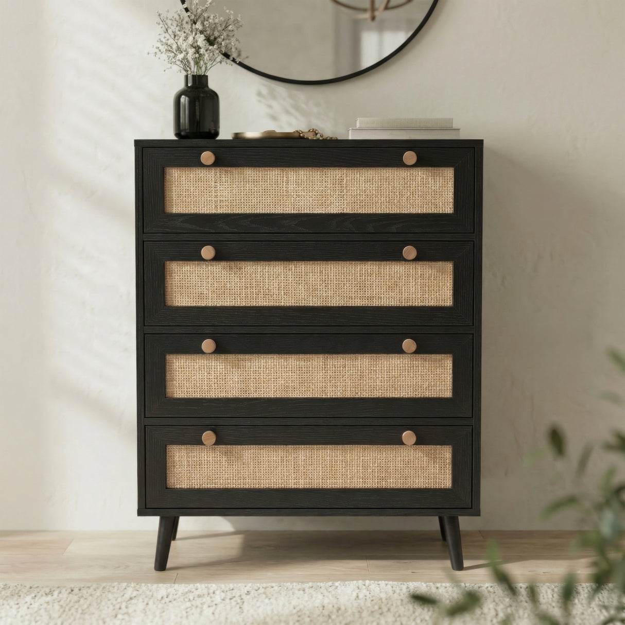 [Black] Wovena 4 drawer rattan chest with cane mesh fronts styled with pampas grass vase and books against moulded wall