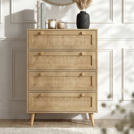 [Oak] Wovena chest styled front-facing against a white panelled wall with books, candles, and a dark vase on top