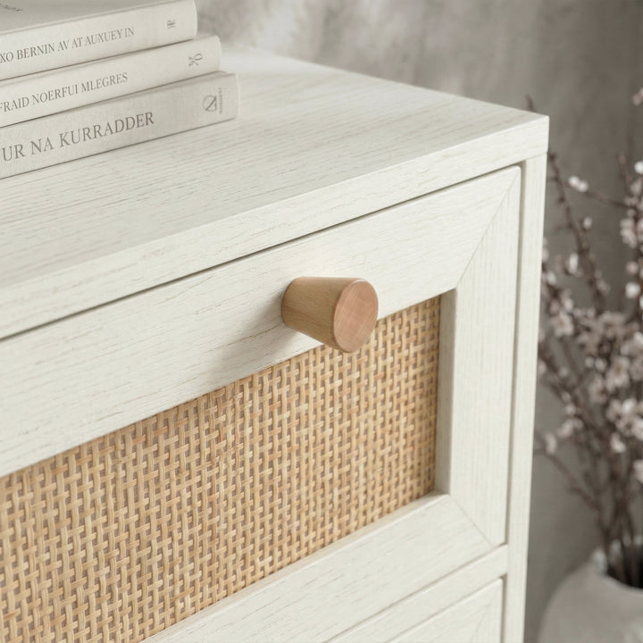 [White] Close-up of natural wood knob and cane panel on white Wovena rattan tallboy chest drawer front