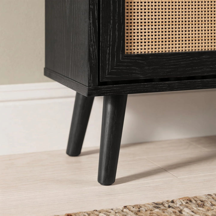 [Black] Wovena Rattan Black 2 Door Shoe Storage Cabinet base close-up showing tapered black legs on light tile floor with black grain cabinet body and rattan door panel
