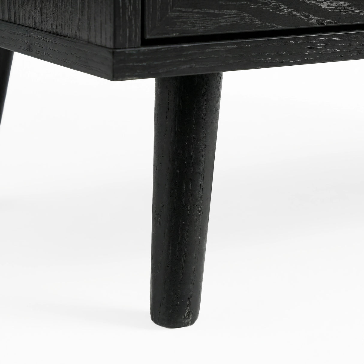 [Black] Wovena rattan chest tapered leg detail at base corner of the black painted frame