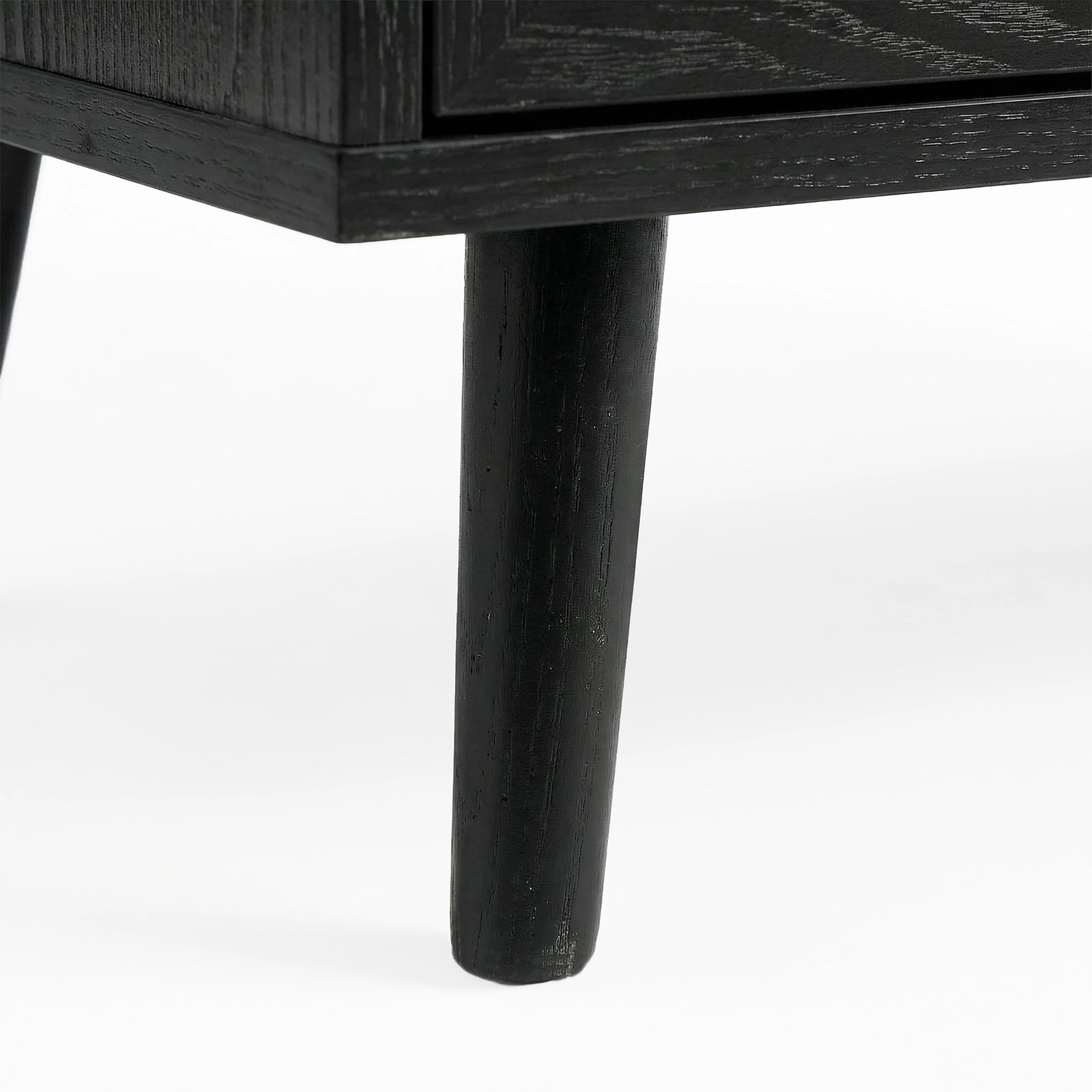 [Black] Wovena rattan chest tapered leg detail at base corner of the black painted frame