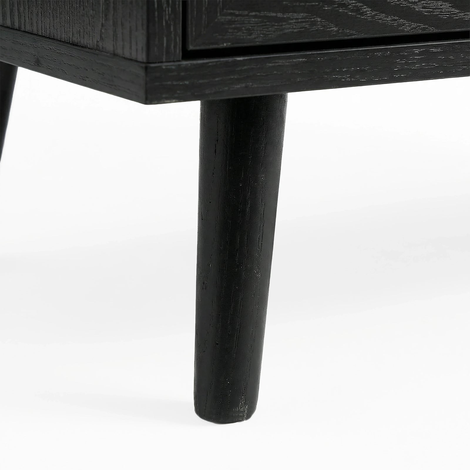 [Black] Wovena rattan chest tapered leg detail at base corner of the black painted frame