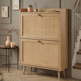 [Oak] Wovena Rattan Oak 2 Door Shoe Storage Cabinet angled in grey hallway with staircase, black side table, peach vase, and succulent and reed diffuser on top shelf