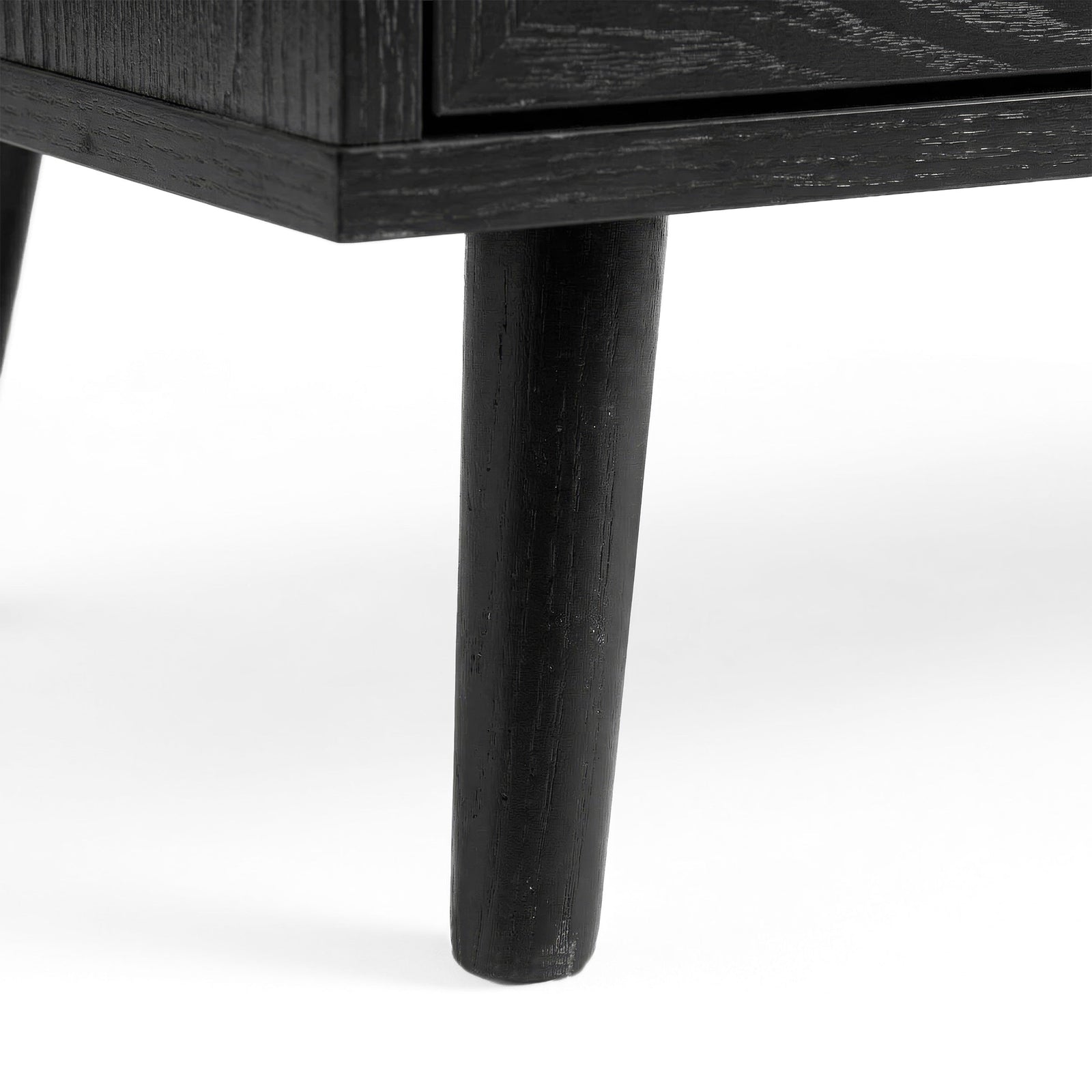 [Black] Wovena rattan tallboy leg detail showing architectural splayed base