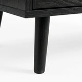 [Black] Wovena furniture leg detail displaying solid wood construction and mid-century tapered profile against plain floor