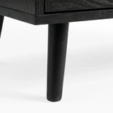 [Black] Tapered wooden leg detail on Wovena rattan wardrobe, painted black and angled outward from corner