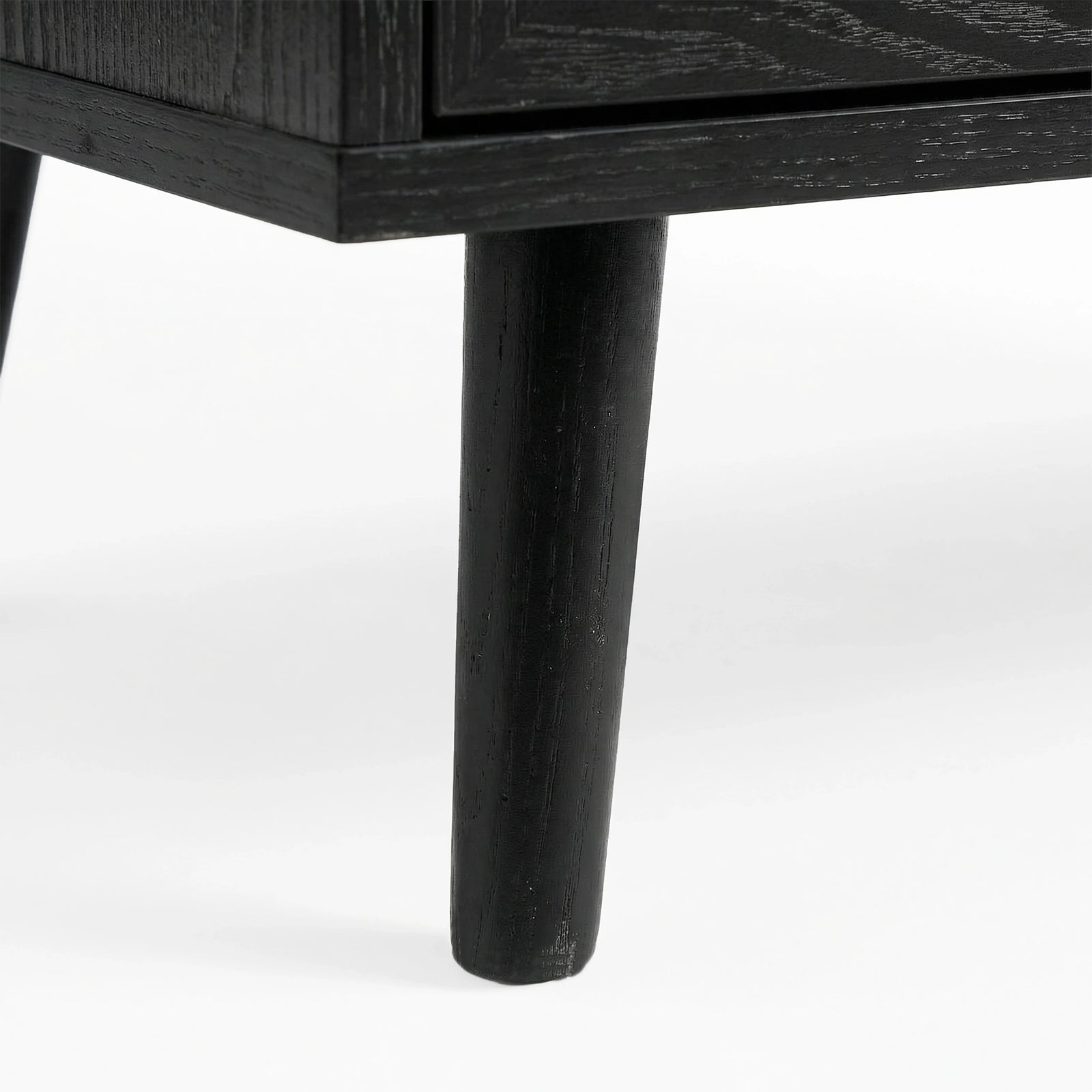 [Black] Tapered wooden leg detail on Wovena rattan wardrobe, painted black and angled outward from corner