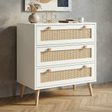 [White] Wovena White Rattan 3 Chest of Drawers, Pine legs angled look against a modern textured grey wall.