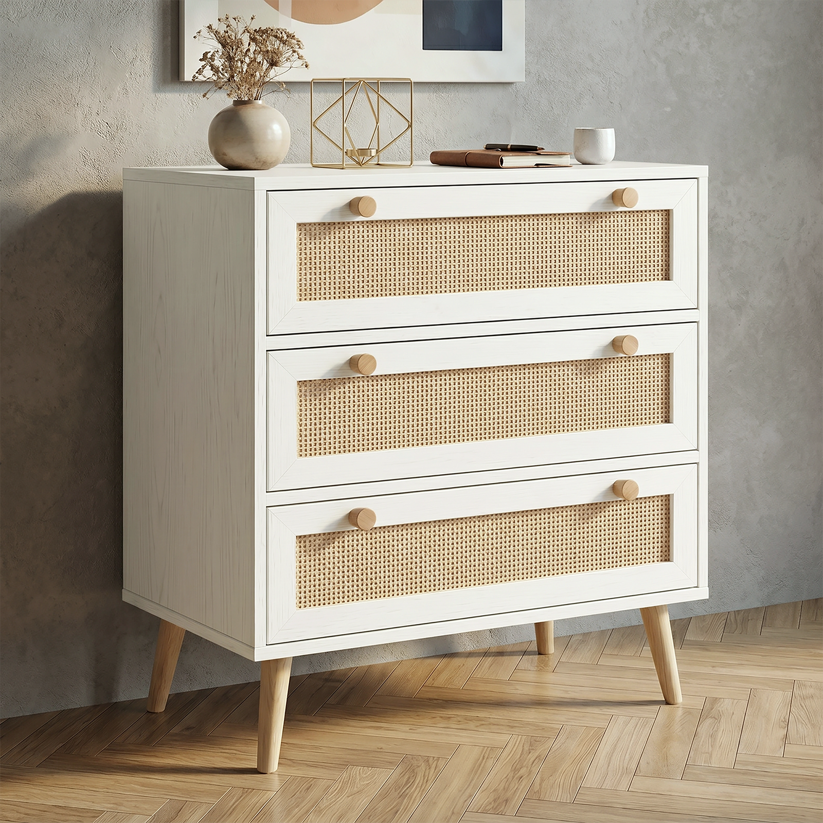 [White] Wovena White Rattan 3 Chest of Drawers, Pine legs angled look against a modern textured grey wall.