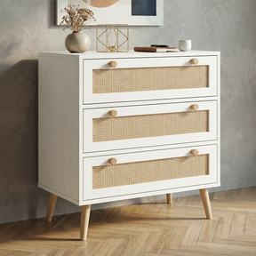 [White] Wovena White Rattan 3 Chest of Drawers, Pine legs angled look against a modern textured grey wall.
