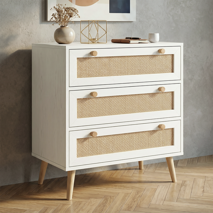 [White] Wovena White Rattan 3 Chest of Drawers, Pine legs angled look against a modern textured grey wall.