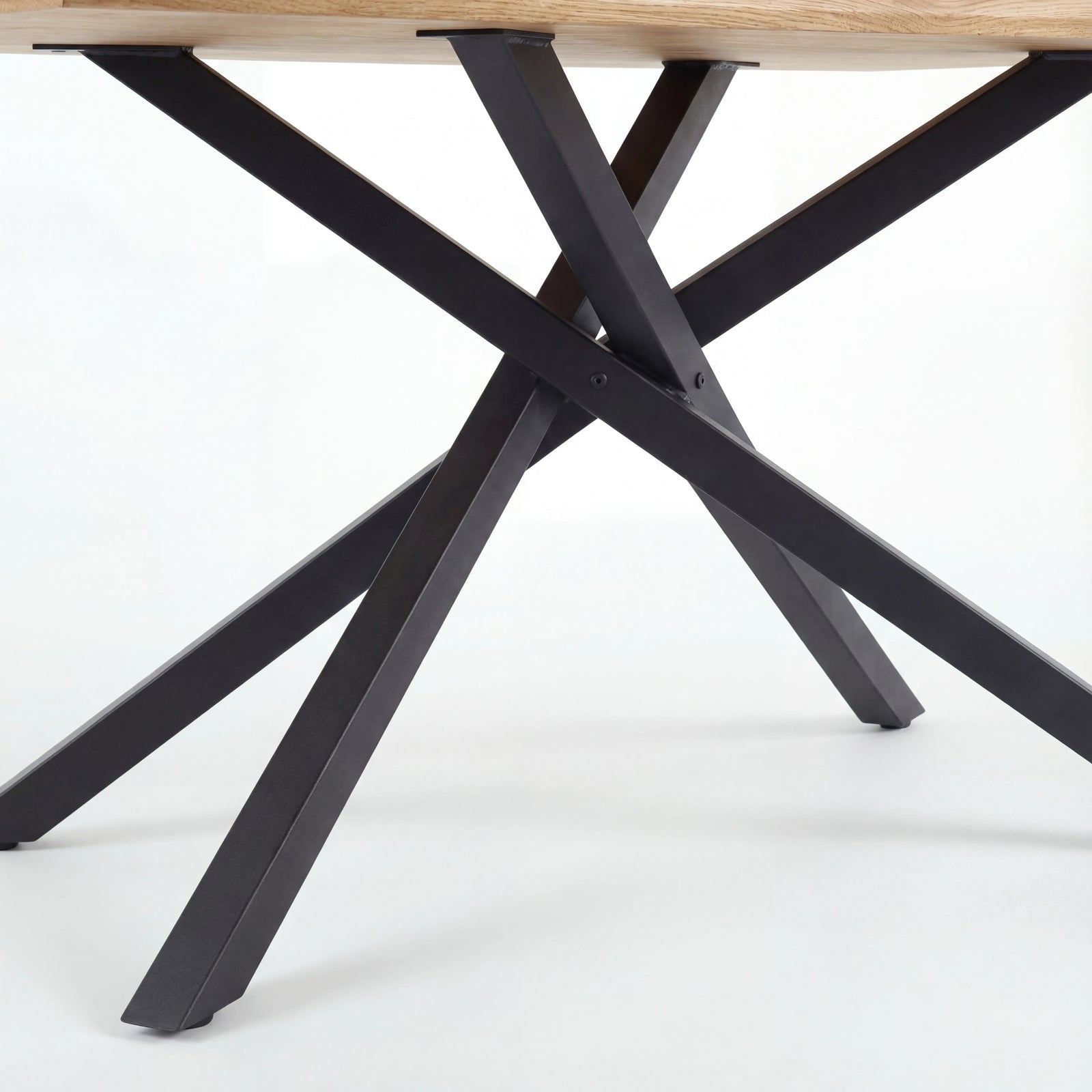 [4 Seater | Grey] Detail of Xylon dining table's black star base, four crossed metal legs supporting oak top