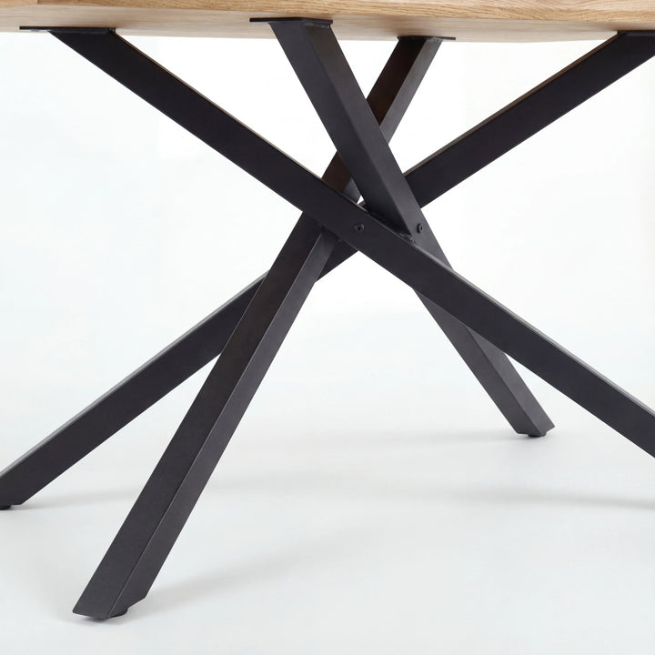 [4 Seater | Grey] Detail of Xylon dining table's black star base, four crossed metal legs supporting oak top