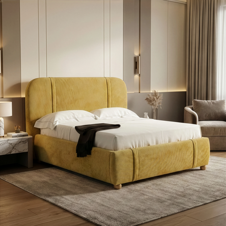 Yellow fabric king-size bed frame positioned at an angle in a softly lit bedroom